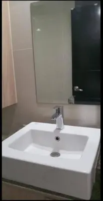 a white sink in a bathroom with a mirror at JRM Staycation Naia T3 in Manila