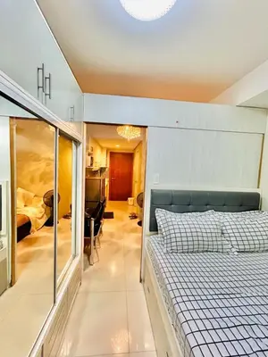 a bedroom with a bed and a glass wall at 1Bedroom Pool View - MOA Shell Residences Near Airport in Manila