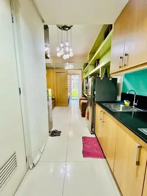 a kitchen with a long hallway with a sink and refrigerator at 1Bedroom Pool View - MOA Shell Residences Near Airport in Manila