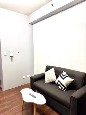 a living room with a black couch and a table at City chic in the heart of Makati #4609 in Manila