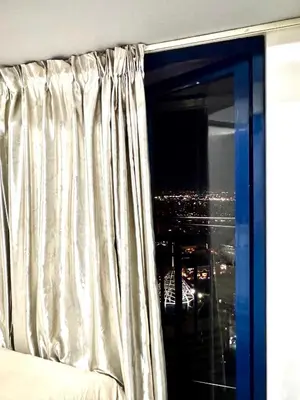 a bedroom with a window with a view of a city at City chic in the heart of Makati #4609 in Manila