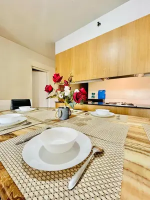 a table with plates and utensils on top of it at SGG Place 2 Bedroom Shell Residences Mall of Asia Near NAIA in Manila