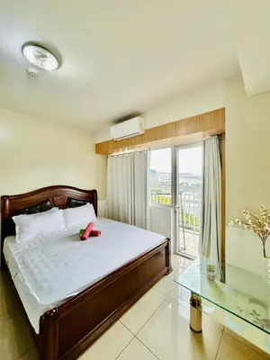 a bedroom with a bed and a glass table at SGG Place 2 Bedroom Shell Residences Mall of Asia Near NAIA in Manila
