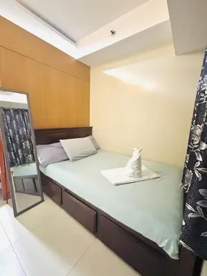 a small room with a bed and a mirror at Shell Residences - Rhoi in Manila