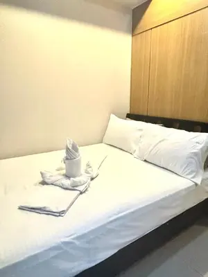 a bed with a hat and towels on it at Shell Residences - Rhoi in Manila