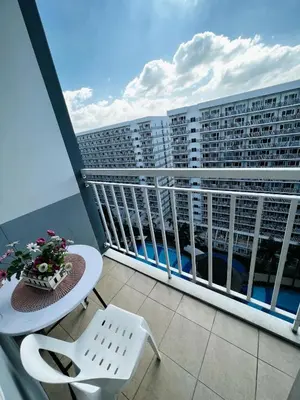 a balcony with a table and chairs and a building at Shell Residences - Rhoi in Manila