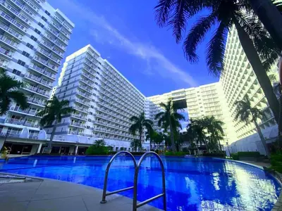 a swimming pool in front of two tall buildings at 1BR Affordable Room infront of Mall of Asia Near Airport in Manila