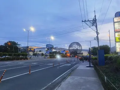 an empty city street at night with a ferris wheel at 1BR Affordable Room infront of Mall of Asia Near Airport in Manila