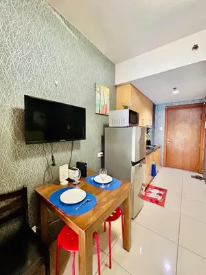 a small kitchen with a table and a refrigerator at 1BR Affordable Room infront of Mall of Asia Near Airport in Manila