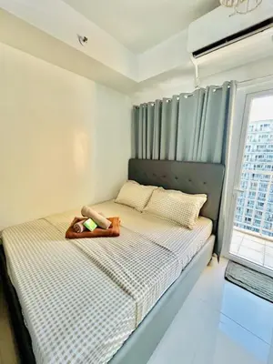 a bedroom with a bed with a teddy bear on it at SGG Place Deluxe Room- MOA Shell Residences Near NAIA in Manila