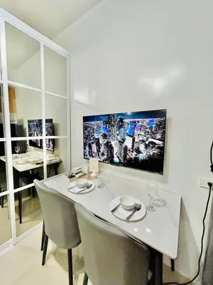 a white dining room table with chairs and a tv on the wall at SGG Place Deluxe Room- MOA Shell Residences Near NAIA in Manila