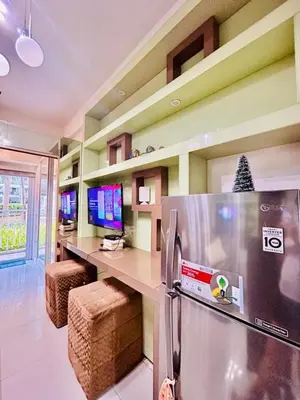 a kitchen with a refrigerator and a counter with televisions at SGG Suite Room Pool View - Shell Residences MOA Pasay Near NAIA in Manila