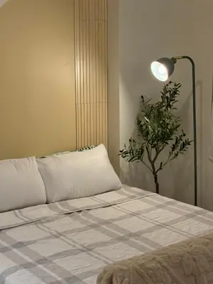 a room with a bed with a lamp and a plant at Meraki Stays - ETANA - SMDC Hope Residences in Trece Martires