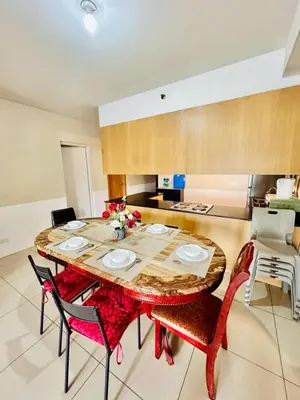 a dining room with a wooden table and chairs at SGG Manila 2Bedroom MOA View - Shell Residences MOA Near Airport in Manila