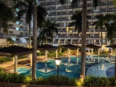 a hotel with a swimming pool and a building at SGG Manila 2Bedroom MOA View - Shell Residences MOA Near Airport in Manila