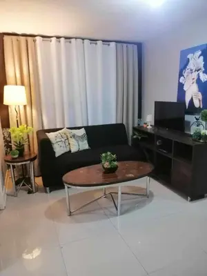 a living room with a couch and a coffee table at Royale 2BR Condo unit with free WiFi in Imus