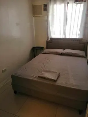 a bed sitting in a bedroom with a window at Royale 2BR Condo unit with free WiFi in Imus