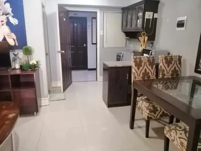 a kitchen with a table and chairs in a room at Royale 2BR Condo unit with free WiFi in Imus