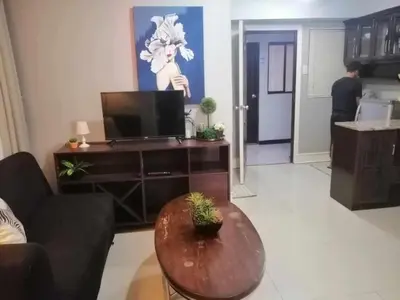 a living room with a tv and a table at Royale 2BR Condo unit with free WiFi in Imus