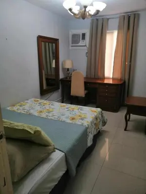 a bedroom with a bed and a desk and a mirror at Royale 2BR Condo unit with free WiFi in Imus