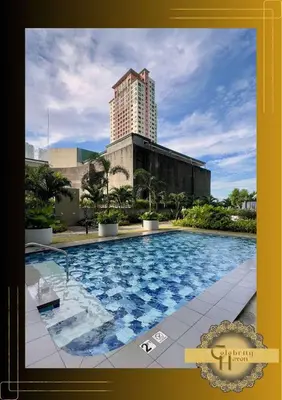 a large swimming pool with a tall building in the background at Celebrity Haven in Manila