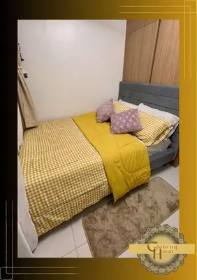 a bed with a yellow blanket and pillows on it at Celebrity Haven in Manila