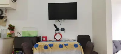 a table with chairs and a tv on a wall at La Casa Celiacay in Sangley Point Naval Station