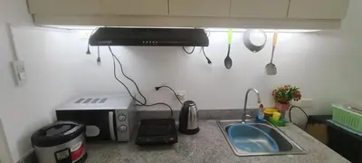 a kitchen counter with a sink and a microwave at La Casa Celiacay in Sangley Point Naval Station