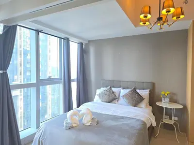 a bedroom with a bed with two towels on it at BGC Cosy Nest Uptown Parksuites Tower 1 Near Nice Restaurants and Malls in Manila