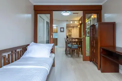 a bedroom with a bed and a dining room at 2br Forbeswood Heights in BGC near St Lukes in Manila