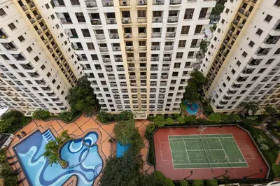 a view of two tall buildings with a tennis court at 2br Forbeswood Heights in BGC near St Lukes in Manila