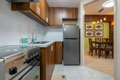 a kitchen with a stainless steel refrigerator and a dining room at 2br Forbeswood Heights in BGC near St Lukes in Manila