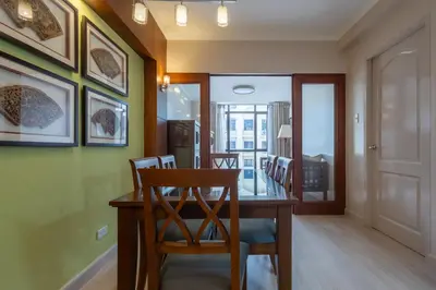 a dining room with a wooden table and chairs at 2br Forbeswood Heights in BGC near St Lukes in Manila