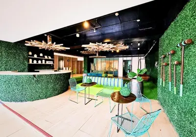 a lobby with chairs and tables and a green wall at Cozi Makati Executive Studio balcony in Manila