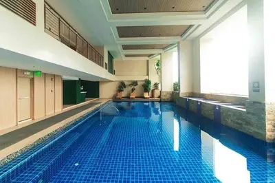 a large swimming pool in a large building at Cozi Makati Executive Studio balcony in Manila