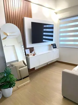 a living room with a large tv and a couch at The Hive Staycation - SMDC Hope Residences in Trece Martires