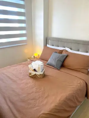a bed with a basket on it with a window at The Hive Staycation - SMDC Hope Residences in Trece Martires
