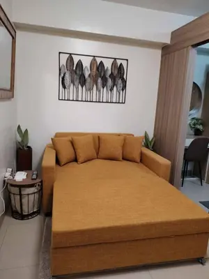 a bedroom with a large bed and a table at Shore Residence Tower III in Manila