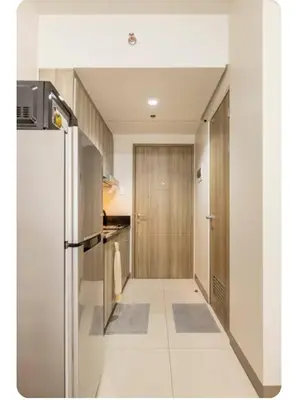 a kitchen with a stainless steel refrigerator and a hallway at S-Residence Staycation IKEA,MOA,PICC in Manila