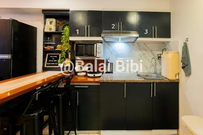 a kitchen with black cabinets and a counter top at Balai Bibi at Urban Deca Homes Ortigas 3Br in Manila