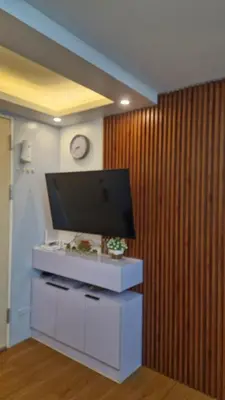 a living room with a flat screen tv on a wall at Cozy RC 2BR w loft Netflix Prime KTV Games in Manila