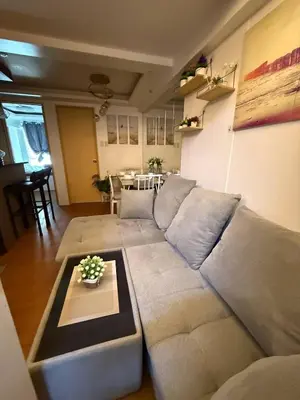 a living room with a couch and a table at Cozy RC 2BR w loft Netflix Prime KTV Games in Manila