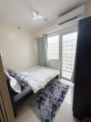 a small bedroom with a bed and a large window at 2BR SHORE FAMILY GROUPs AFFORDABLE STAYCATION in Manila