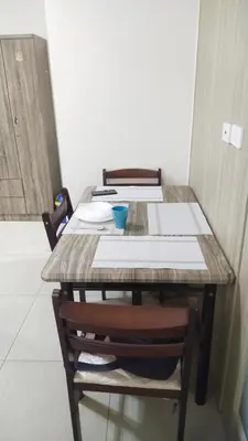 a wooden table with chairs and a table with papers on it at 2BR SHORE FAMILY GROUPs AFFORDABLE STAYCATION in Manila