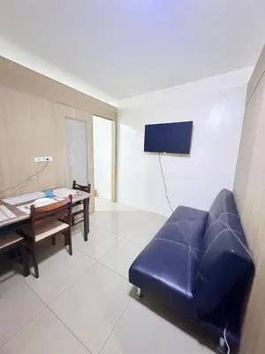 a living room with a blue couch and a table at 2BR SHORE FAMILY GROUPs AFFORDABLE STAYCATION in Manila