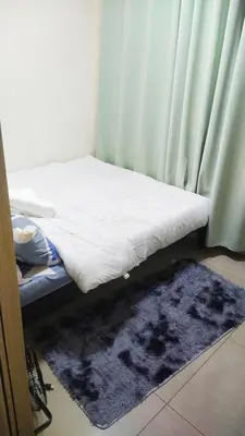 a small bed with a blue rug next to a window at 2BR SHORE FAMILY GROUPs AFFORDABLE STAYCATION in Manila