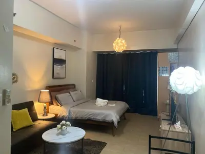 a living room with a bed and a couch at M&N Condotel in Manila