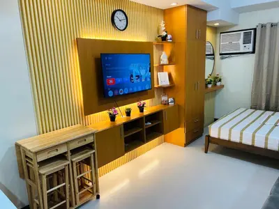 a living room with a tv on a wall at Unit 23L T-B The Pearl Place Ortigas in Manila
