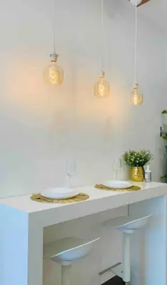 a white kitchen with two sinks and lights at Cityscape Suite in Manila