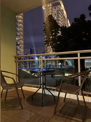 a table and chairs on a balcony with a view of a city at Azure Urban Resort-The Rustic Escape in Manila